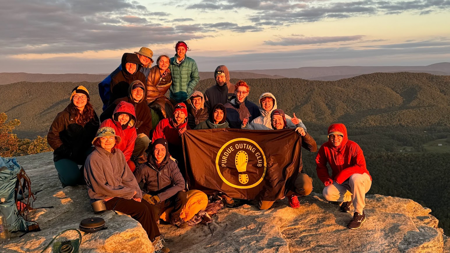 Purdue Outing Club trip leaders holding a POC flag.